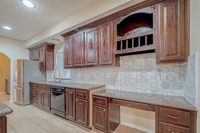 kitchen featuring stainless steel refrigerator, dishwasher, sink, decorative backsplash, and light tile patterned flooring