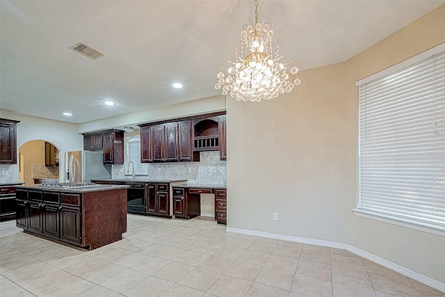 kitchen with a center island, a chandelier, decorative light fixtures, dark brown cabinets, and appliances with stainless steel finishes