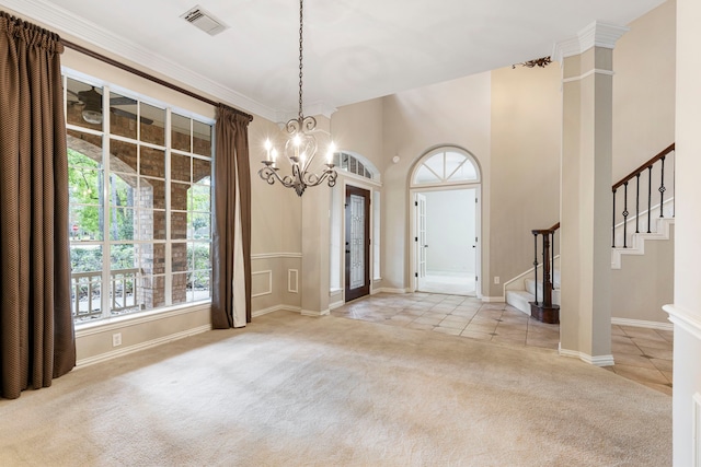 foyer featuring crown molding, a towering ceiling, light colored carpet, and an inviting chandelier