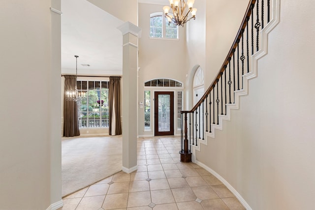 foyer entrance featuring light carpet, a healthy amount of sunlight, and a notable chandelier