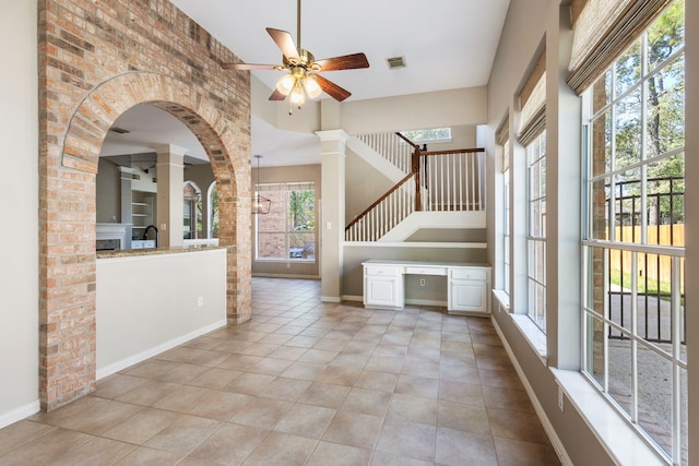 interior space with a healthy amount of sunlight, light tile patterned flooring, and a towering ceiling