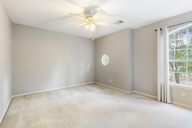 empty room with ceiling fan and light carpet