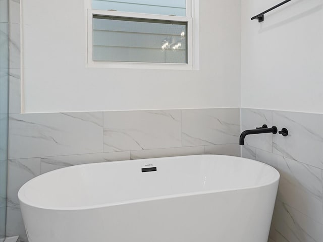 bathroom with a bathtub and tile walls