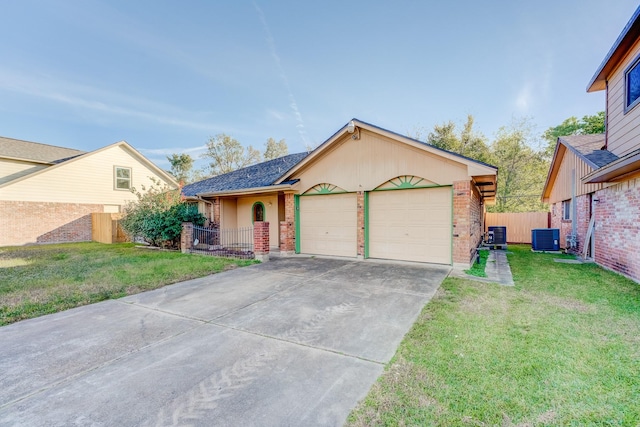 view of front of home with central AC unit, a garage, and a front yard