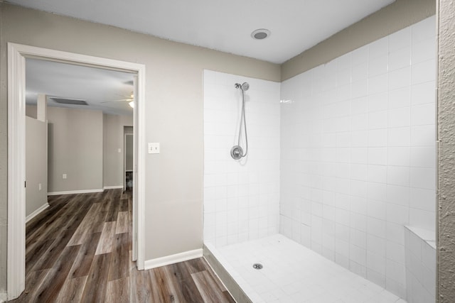 bathroom featuring hardwood / wood-style floors, ceiling fan, and tiled shower