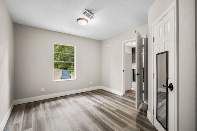 spare room featuring wood-type flooring and a textured ceiling