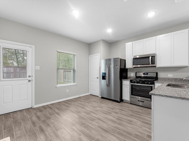 kitchen with sink, light hardwood / wood-style floors, plenty of natural light, and appliances with stainless steel finishes