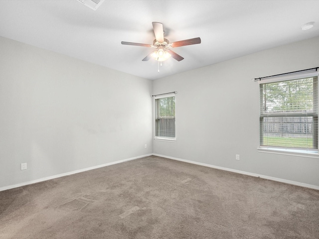 empty room featuring carpet, a wealth of natural light, and ceiling fan