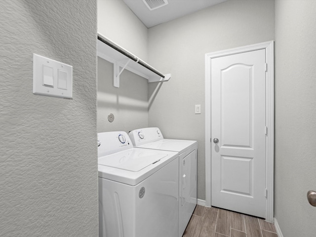 washroom with light wood-type flooring and washing machine and clothes dryer