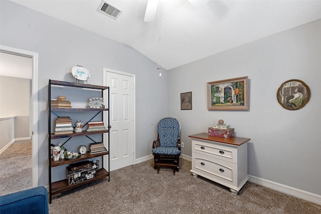 living area featuring ceiling fan, carpet floors, and vaulted ceiling