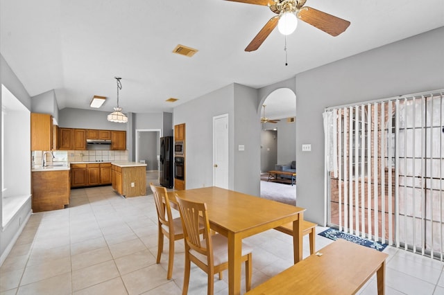 dining area featuring ceiling fan, sink, and light tile patterned flooring