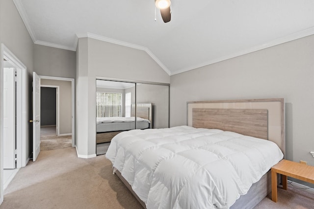 carpeted bedroom featuring ceiling fan, vaulted ceiling, ornamental molding, and a closet