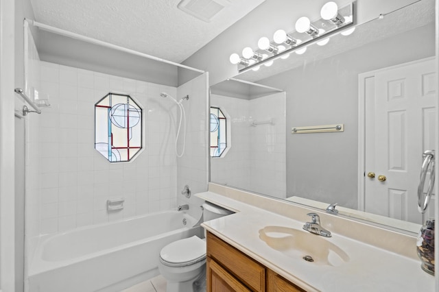 full bathroom featuring tiled shower / bath combo, tile patterned floors, a textured ceiling, toilet, and vanity