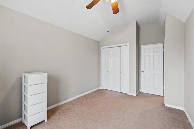 unfurnished bedroom with ceiling fan, lofted ceiling, light carpet, and a closet