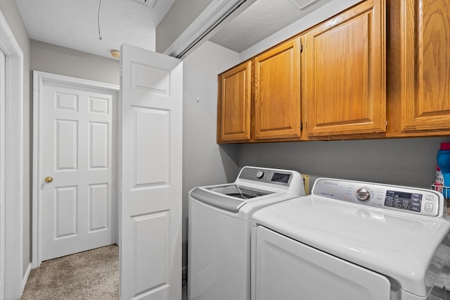 laundry room featuring a textured ceiling, cabinets, light carpet, and washing machine and dryer