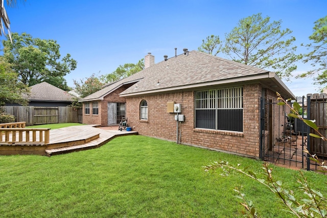 rear view of house featuring a yard and a deck