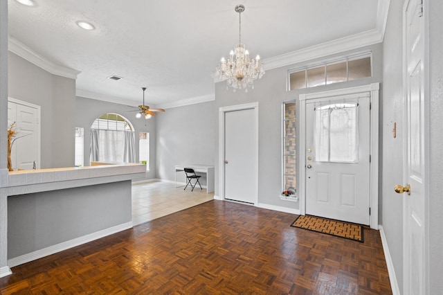 foyer entrance with a textured ceiling, dark parquet floors, ornamental molding, and ceiling fan with notable chandelier