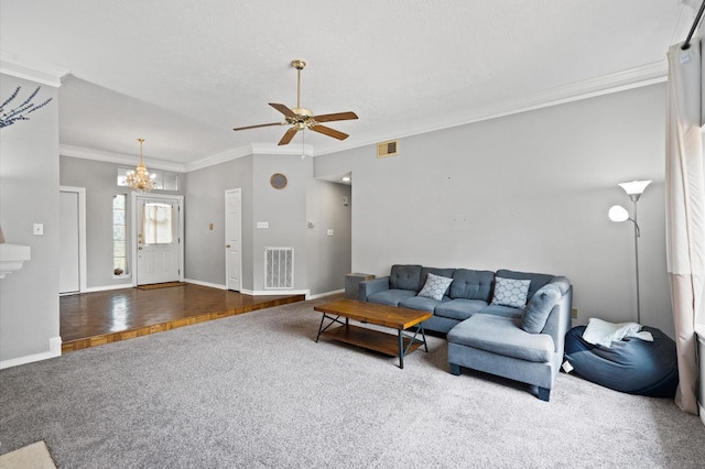 living room with dark hardwood / wood-style floors, ornamental molding, and ceiling fan with notable chandelier