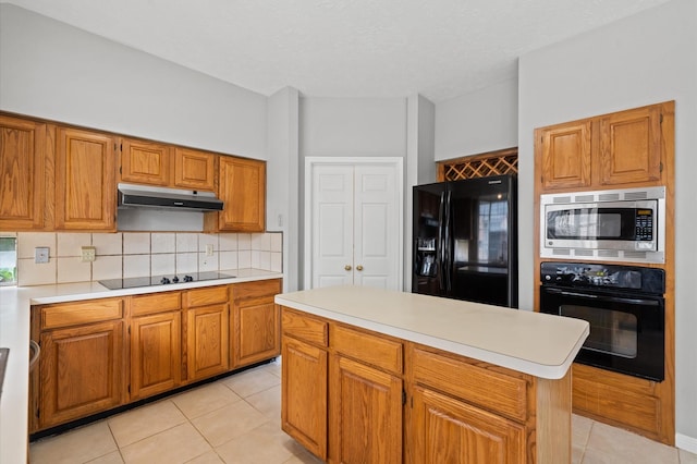 kitchen featuring black appliances, decorative backsplash, a center island, and light tile patterned flooring