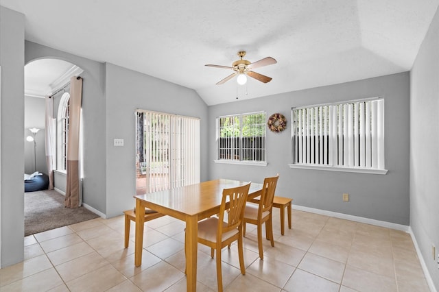 tiled dining room with a textured ceiling, ceiling fan, and lofted ceiling