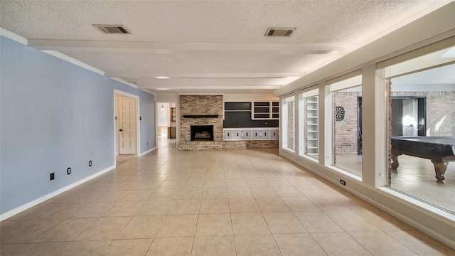 unfurnished living room featuring built in shelves, a textured ceiling, a fireplace, light tile patterned flooring, and pool table