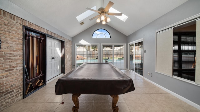 recreation room featuring a skylight, ceiling fan, pool table, high vaulted ceiling, and light tile patterned flooring