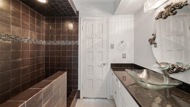 bathroom with tile patterned floors, vanity, and a tile shower