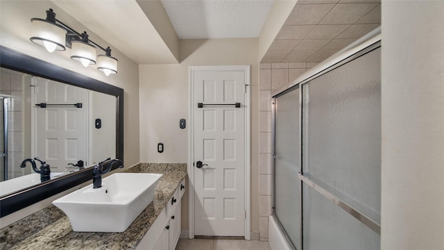 bathroom with tile patterned floors, shower / bath combination with glass door, and vanity