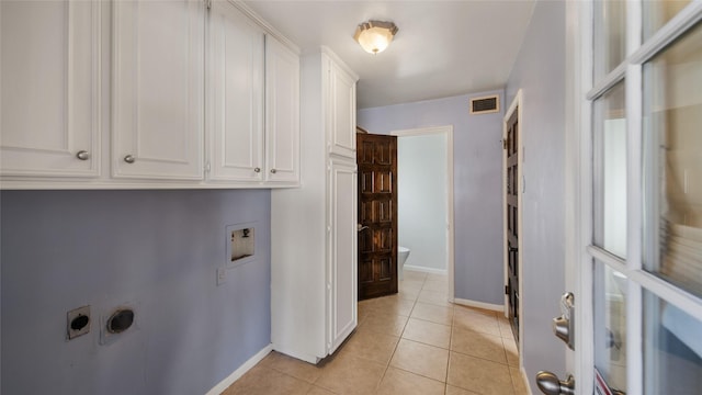 laundry room with electric dryer hookup, light tile patterned flooring, cabinets, and washer hookup