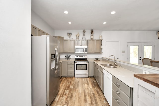 kitchen featuring appliances with stainless steel finishes, french doors, sink, light hardwood / wood-style floors, and butcher block counters