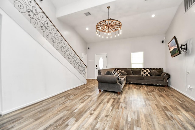 living room featuring light hardwood / wood-style floors, high vaulted ceiling, and a chandelier