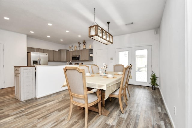 dining space with french doors, light hardwood / wood-style flooring, and sink