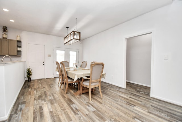 dining area featuring french doors, light wood-type flooring, and sink