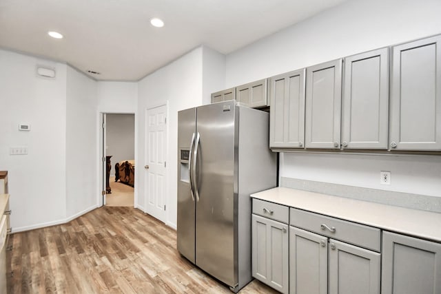 kitchen featuring gray cabinetry, stainless steel fridge, and light hardwood / wood-style flooring