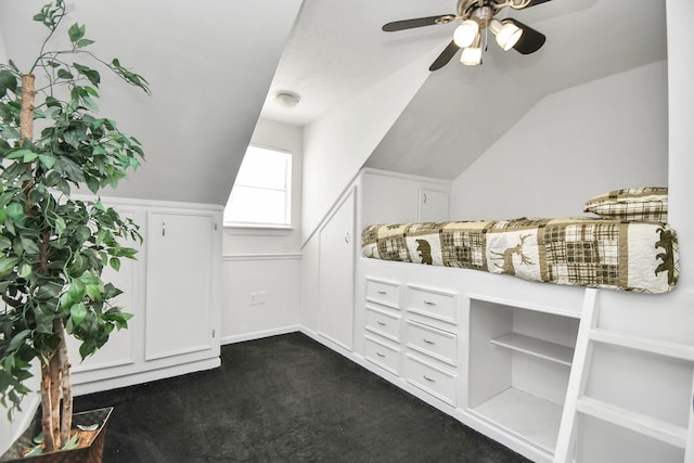 walk in closet with dark carpet, ceiling fan, and lofted ceiling