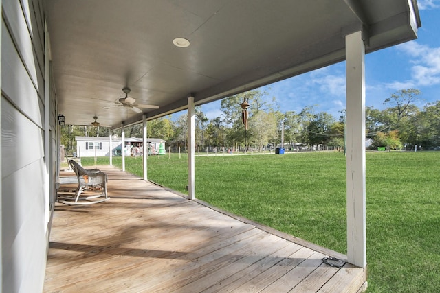 deck featuring ceiling fan and a yard