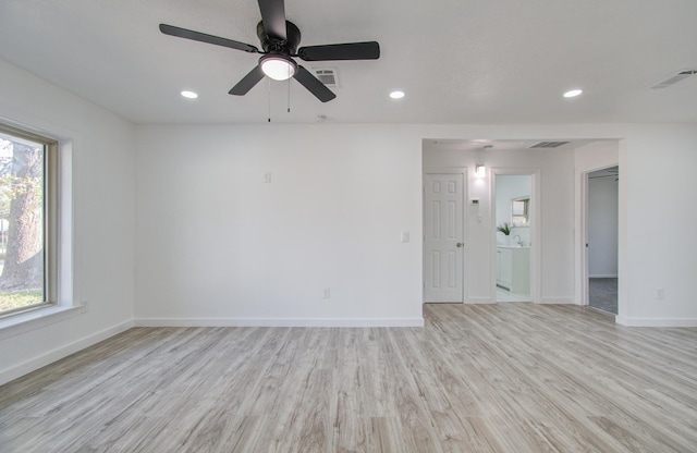 empty room with ceiling fan, a healthy amount of sunlight, and light hardwood / wood-style flooring