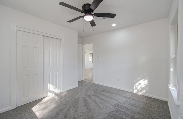 unfurnished bedroom featuring carpet, a closet, and ceiling fan