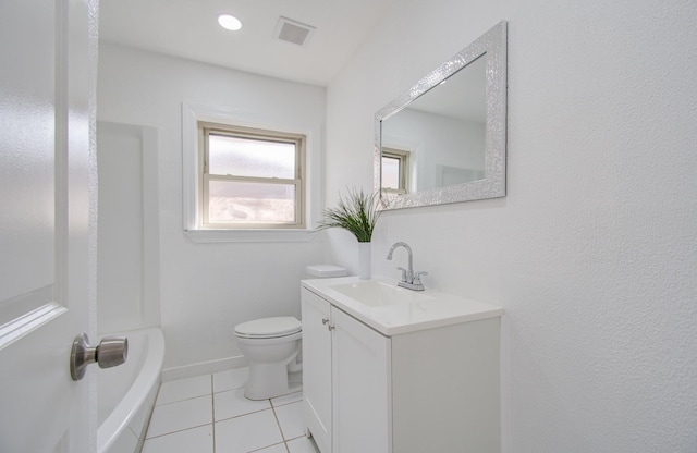 bathroom featuring toilet, vanity, tile patterned floors, and a tub