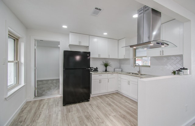 kitchen featuring black refrigerator, sink, light hardwood / wood-style flooring, island range hood, and white cabinetry