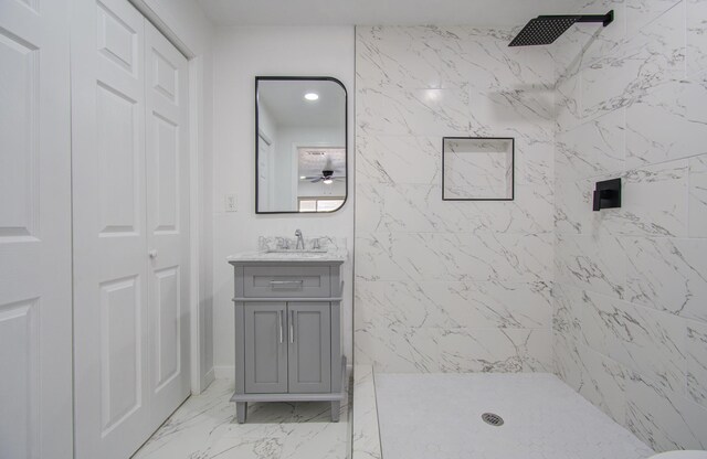 bathroom featuring a tile shower, vanity, and ceiling fan