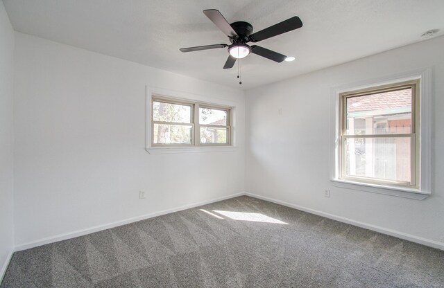 empty room with carpet, ceiling fan, and a healthy amount of sunlight