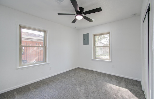 empty room featuring electric panel, ceiling fan, and carpet floors