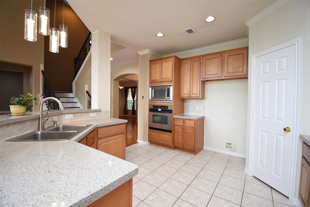 kitchen featuring decorative backsplash, stainless steel appliances, crown molding, sink, and pendant lighting