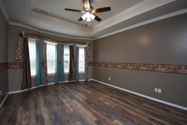 spare room featuring dark hardwood / wood-style floors, a raised ceiling, and ornamental molding