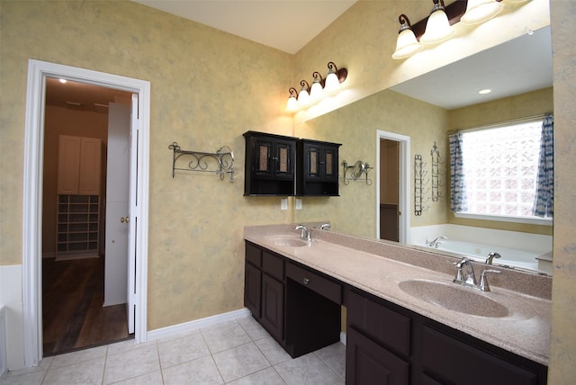 bathroom with tile patterned flooring, vanity, and a tub