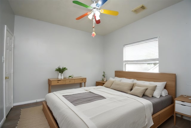 bedroom with dark hardwood / wood-style flooring and ceiling fan