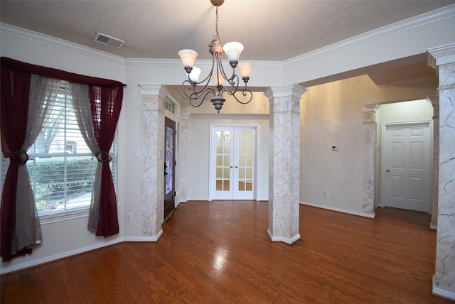 unfurnished dining area featuring dark wood-type flooring, french doors, a chandelier, ornamental molding, and decorative columns