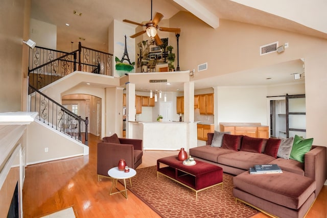 living room featuring beam ceiling, ceiling fan, high vaulted ceiling, and light hardwood / wood-style floors