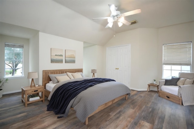 bedroom featuring multiple windows, dark hardwood / wood-style flooring, a closet, and ceiling fan